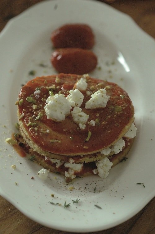 Millefoglie di crêpes con feta al timo, datterini confit e granella di pistacchio