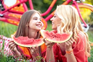 frutta estiva mamma e figlia che mangiano anguria