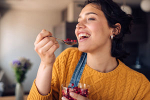 melagrana-ragazza-che-mangia-frutto-del-melograno-maglione-giallo-cucchiaino