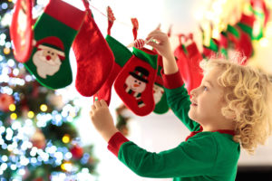 cosa-cucinare-alla-Befana-calza-verde-e-rossa-appesa-con-bambino-biondo-che-gioca